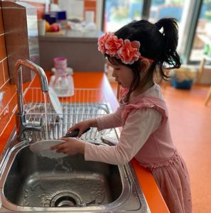 little girl washing dishes